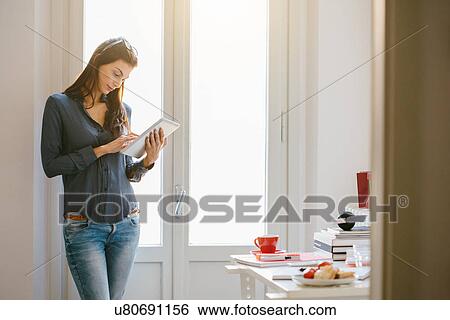 Stock Photograph - Young woman using digital tablet. Fotosearch