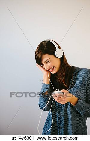 Stock Image - Young woman using headphones. Fotosearch