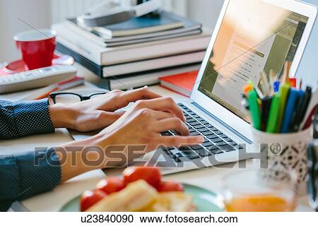 Young woman using laptop while breakfasting View Large Photo Image Stock Image - Young woman using laptop while breakfasting. Fotosearch
