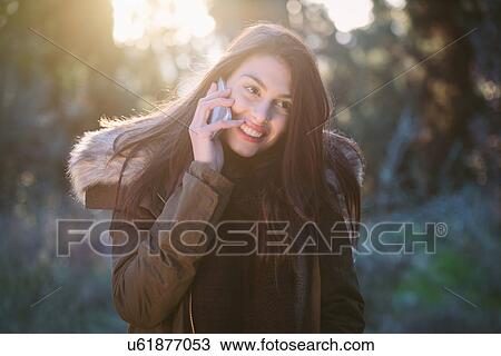 Stock Image - Young woman using telephone. Fotosearch