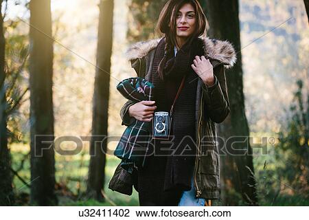 Young woman with camera in the woods View Large Photo Image Stock Image - Young woman with camera in the woods. Fotosearch