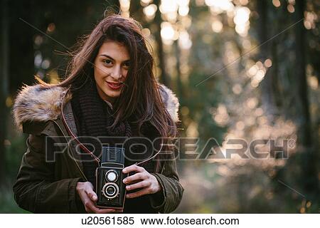Young woman with camera in the woods View Large Photo Image Stock Photography - Young woman with camera in the woods. Fotosearch