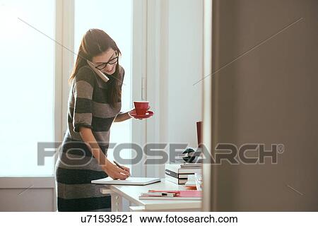 Young woman working in home office View Large Photo Image Stock Image - Young woman working in home office. Fotosearch