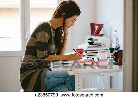 Young woman working in home office View Large Photo Image Stock Photo - Young woman working in home office. Fotosearch
