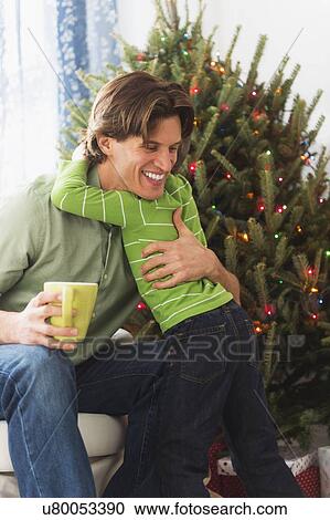 Boy (6-7) embracing father View Large Photo Image Stock Image - Boy (6-7) embracing father. Fotosearch