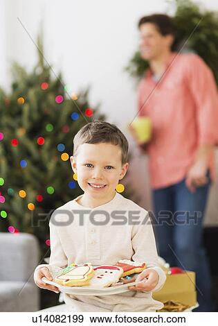 Boy (6-7) holding plate with gingerbread View Large Photo Image Stock Photo - Boy (6-7) holding plate with gingerbread. Fotosearch