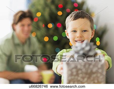 Boy (6-7) holding present View Large Photo Image Stock Photograph - Boy (6-7) holding present. Fotosearch