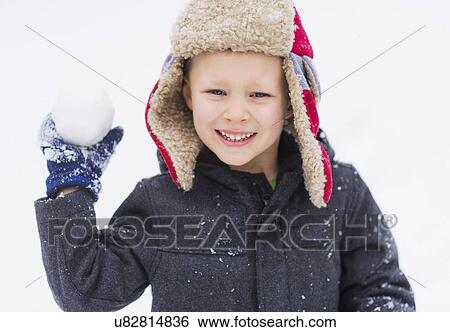 Stock Photograph - Boy (6-7) playing with snowball. Fotosearch