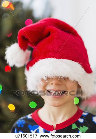 Boy (6-7) wearing santa hat View Large Photo Image Stock Photo - Boy (6-7) wearing santa hat. Fotosearch