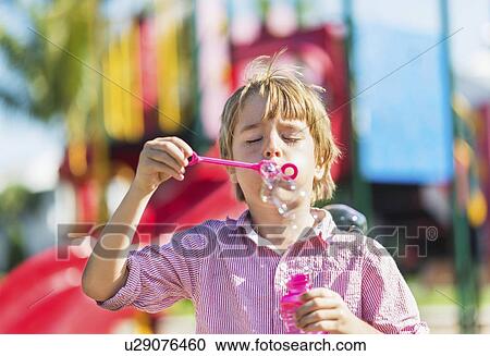Boy (8-9) blowing bubbles View Large Photo Image Stock Image - Boy (8-9) blowing bubbles. Fotosearch