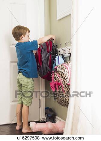 Stock Photo - Boy (8-9) hanging his school bag. Fotosearch