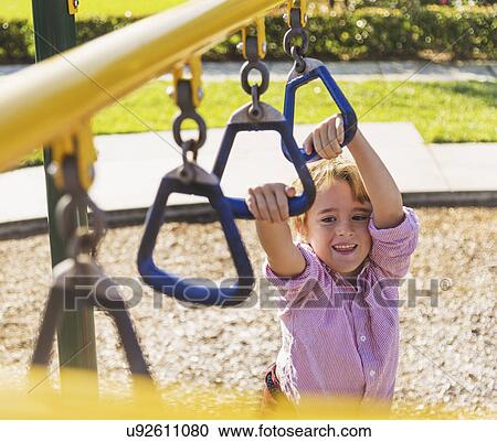 Boy (8-9) playing on playground View Large Photo Image Stock Image - Boy (8-9) playing on playground. Fotosearch