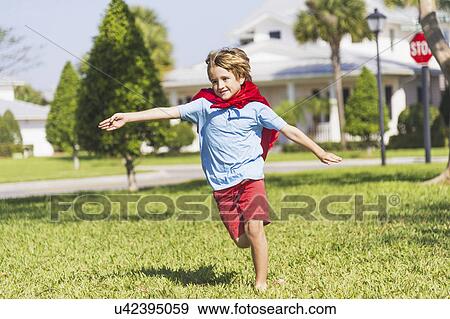 Stock Photo - Boy (8-9) running with cape. Fotosearch