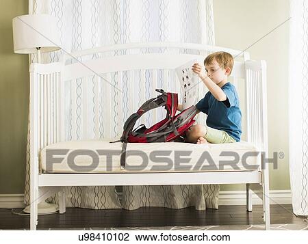 Boy (8-9) sitting on sofa with his school bag View Large Photo Image Stock Image - Boy (8-9) sitting on sofa with his school bag. Fotosearch