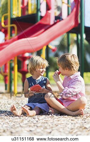 Stock Photo - Boys (4-5, 8-9) playing on playground. Fotosearch