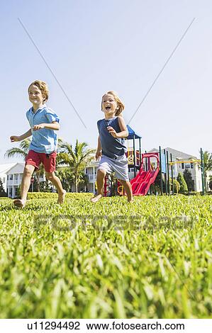 Stock Image - Boys (4-5, 8-9) running. Fotosearch