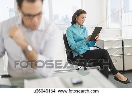 Businessman and businesswoman working in office View Large Photo Image Picture - Businessman and businesswoman working in office. Fotosearch
