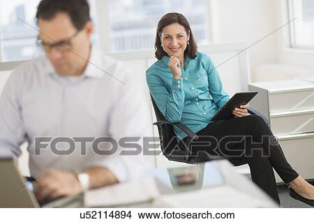 Businessman and businesswoman working in office View Large Photo Image Picture - Businessman and businesswoman working in office. Fotosearch