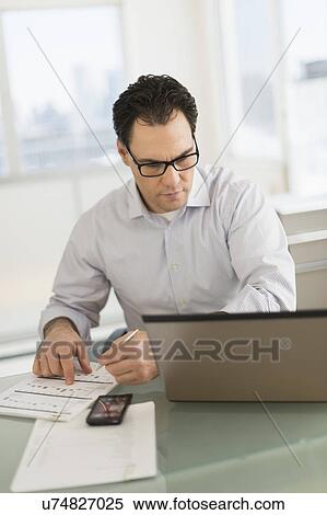 Stock Photography - Businessman using laptop and digital tablet. Fotosearch