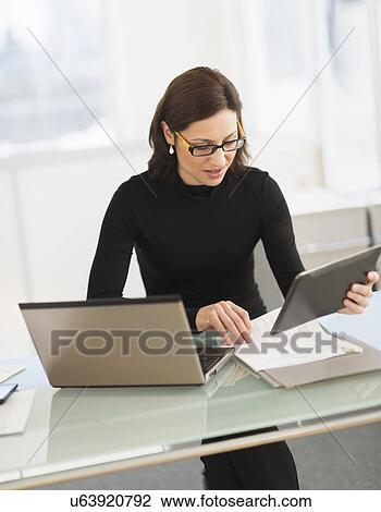 Businesswoman working on laptop and digital tablet View Large Photo Image Stock Image - Businesswoman working on laptop and digital tablet. Fotosearch