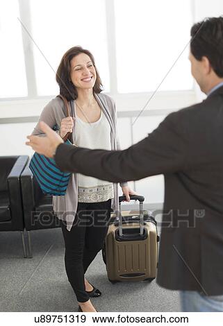 Stock Photo - Couple meeting at airport. Fotosearch