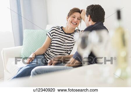 Stock Image - Couple sitting on sofa. Fotosearch
