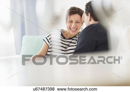 Couple sitting on sofa View Large Photo Image Stock Photo - Couple sitting on sofa. Fotosearch