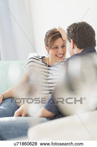 Couple sitting on sofa View Large Photo Image Stock Photo - Couple sitting on sofa. Fotosearch