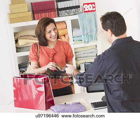 Stock Photograph - Customer paying in clothes store. Fotosearch
