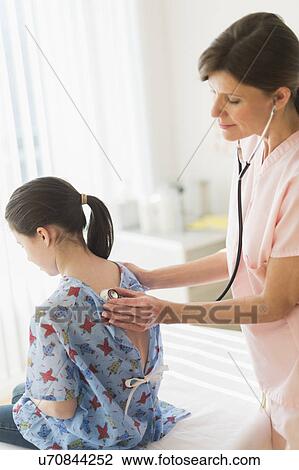 Stock Image - Doctor examining girl (8-9). Fotosearch