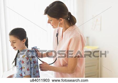 Stock Image - Doctor examining girl (8-9). Fotosearch