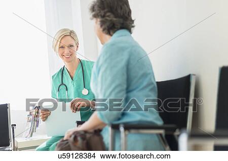 Picture - Doctor talking to patient in waiting room. Fotosearch
