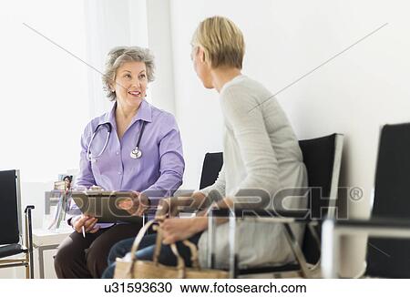 Doctor talking to patient in waiting room View Large Photo Image Stock Image - Doctor talking to patient in waiting room. Fotosearch