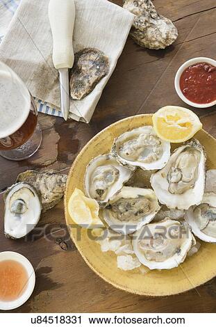 Stock Image - Elevated view of plate with oysters. Fotosearch