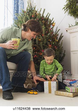 Father and son (6-7) opening Christmas presents View Large Photo Image Stock Photo - Father and son (6-7) opening Christmas presents. Fotosearch