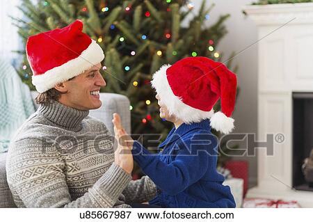 Father and son (6-7) playing next to Christmas tree View Large Photo Image Stock Photo - Father and son (6-7) playing next to Christmas tree. Fotosearch