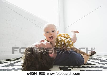 Father playing with baby son (2-5 months) View Large Photo Image Stock Photo - Father playing with baby son (2-5 months). Fotosearch