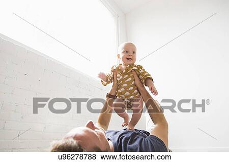 Father playing with baby son (2-5 months) View Large Photo Image Stock Photo - Father playing with baby son (2-5 months). Fotosearch