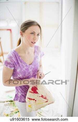 Female artist looking at painting in studio View Large Photo Image Stock Photography - Female artist looking at painting in studio. Fotosearch