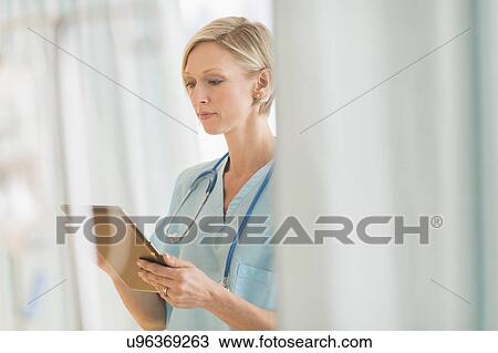Stock Image - Female doctor using tablet PC. Fotosearch