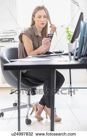Female office worker text messaging View Large Photo Image Stock Image - Female office worker text messaging. Fotosearch