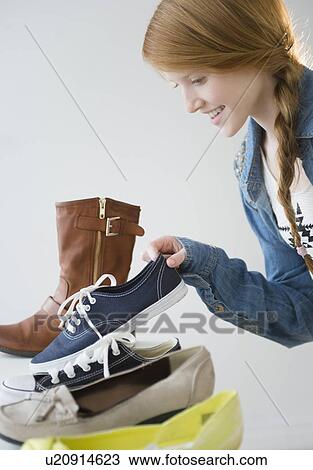Stock Image - Girl (12-13) choosing shoes. Fotosearch