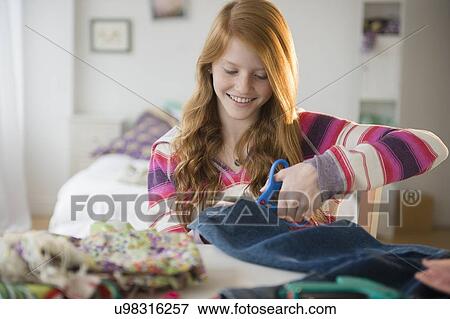 Girl (12-13) cutting clothing View Large Photo Image Stock Photo - Girl (12-13) cutting clothing. Fotosearch