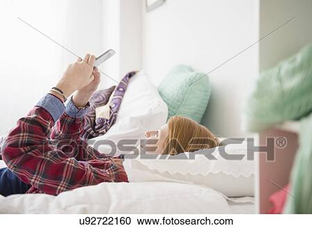Stock Image - Girl (12-13) using mobile phone. Fotosearch