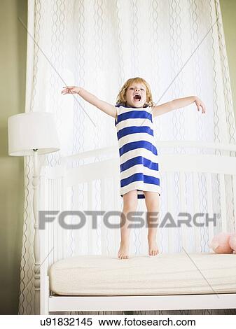 Girl (4-5) jumping on sofa View Large Photo Image Stock Photography - Girl (4-5) jumping on sofa. Fotosearch