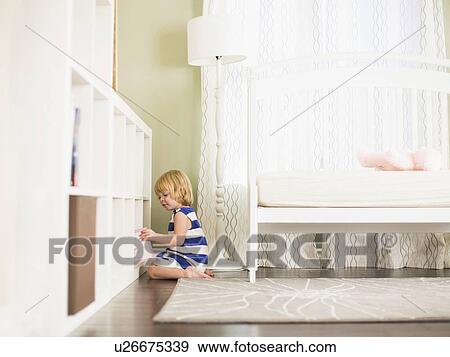 Girl (4-5) taking book from shelf View Large Photo Image Stock Photo - Girl (4-5) taking book from shelf. Fotosearch