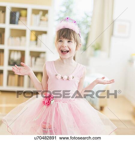 Stock Image - Girl (4-5) wearing tutu dancing in living room. Fotosearch