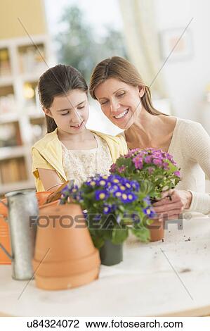 Girl (8-9) and mother potting flowers View Large Photo Image Stock Image - Girl (8-9) and mother potting flowers. Fotosearch