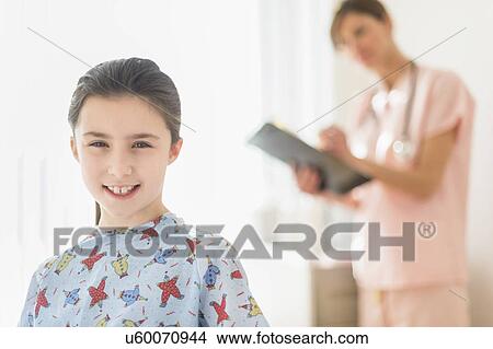 Girl (8-9) in doctor's office View Large Photo Image Picture - Girl (8-9) in doctor's office. Fotosearch