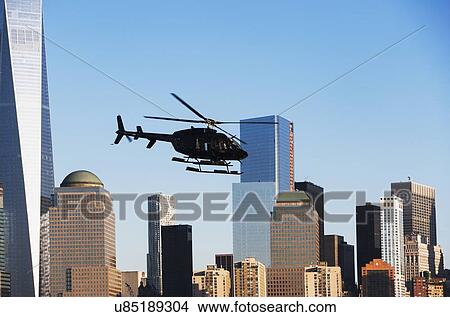 Helicopter flying over city View Large Photo Image Picture - Helicopter flying over city. Fotosearch